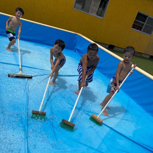 真木保育園のプール掃除を楽しそうにしている男の子たち